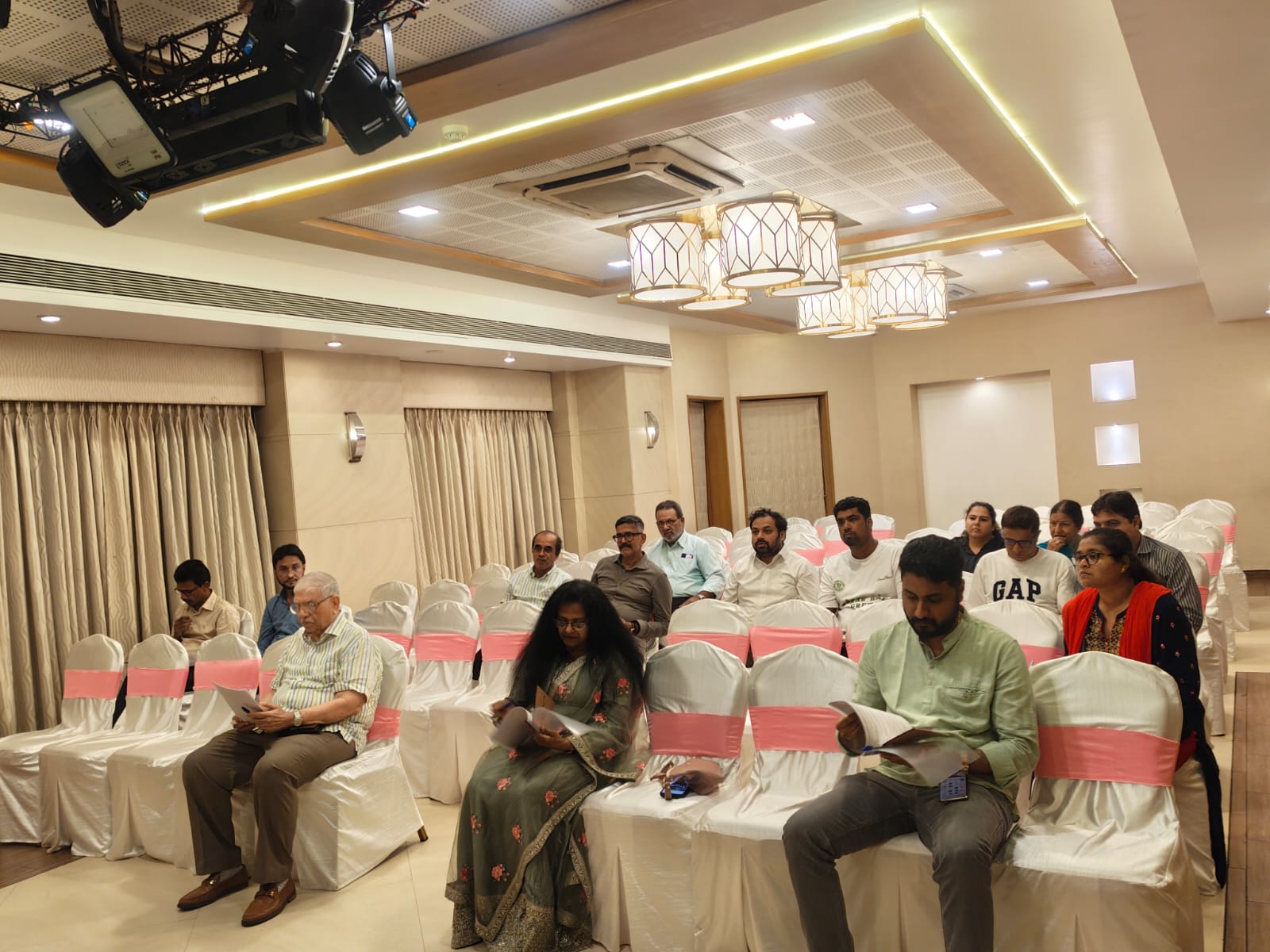 Committee members at the head table reviewing meeting papers during the Annual General Body Meeting