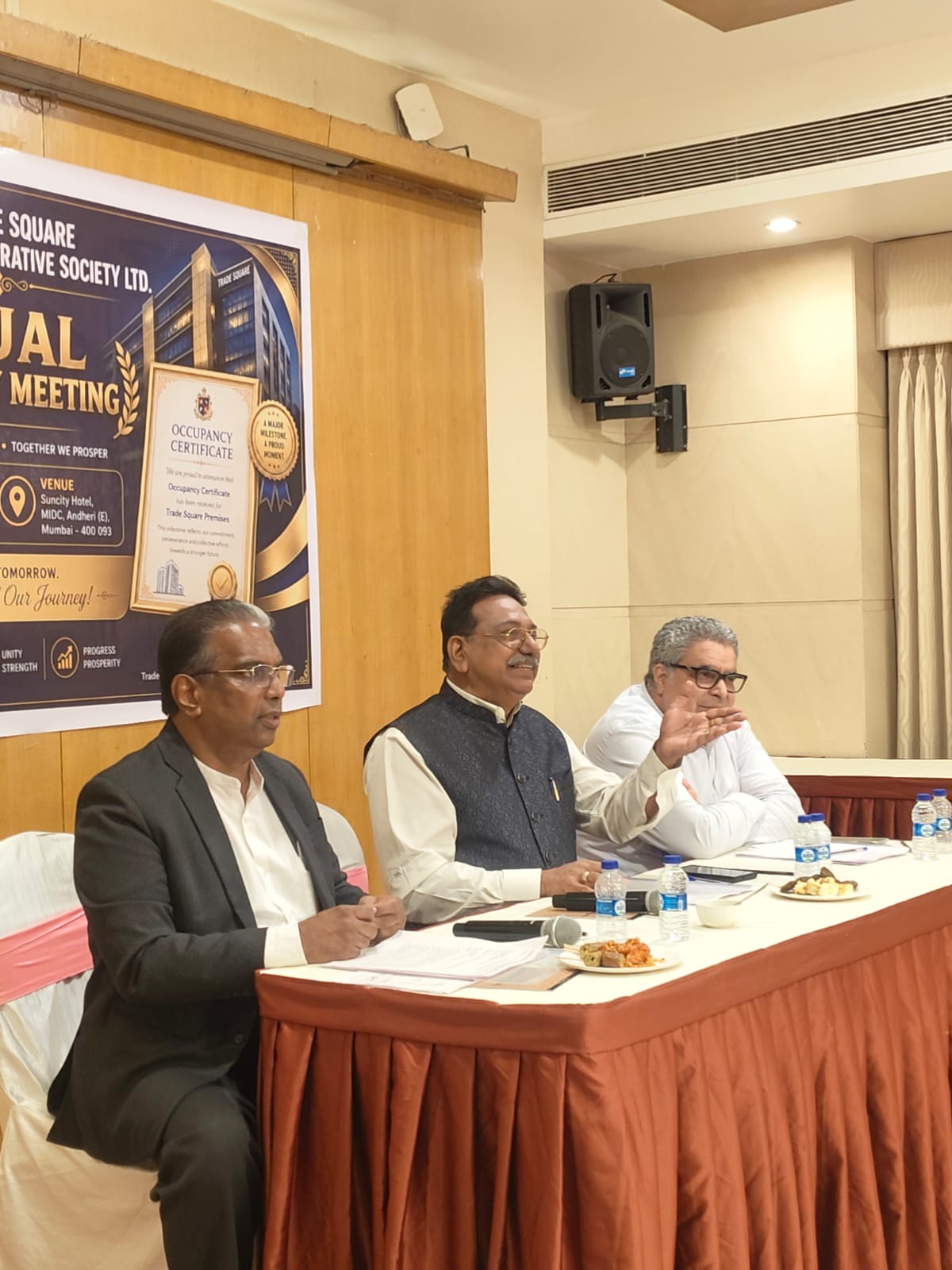 A member standing to speak among attendees during the Annual General Body Meeting
