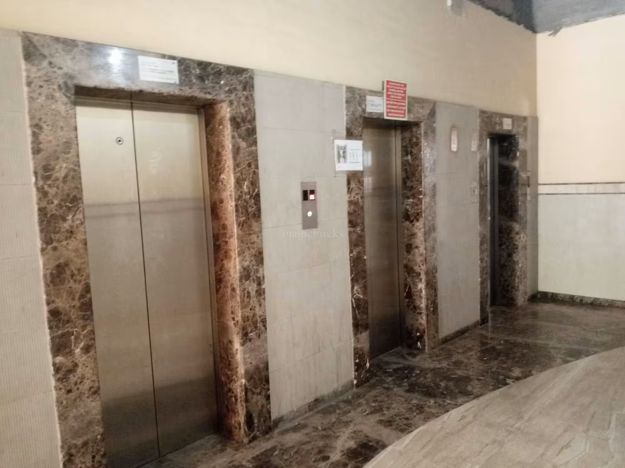 Marble-clad lift lobby inside Trade Square with three elevators