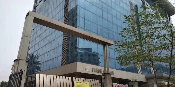 Trade Square glass facade seen from the entrance driveway, with the TRADE SQUARE signage above the lobby